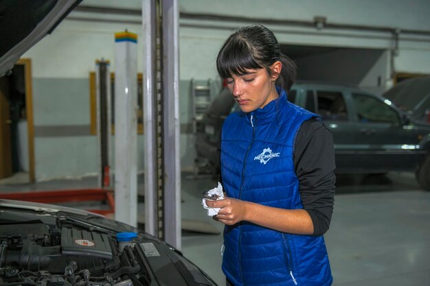 Female mechanic conducting vehicle maintenance